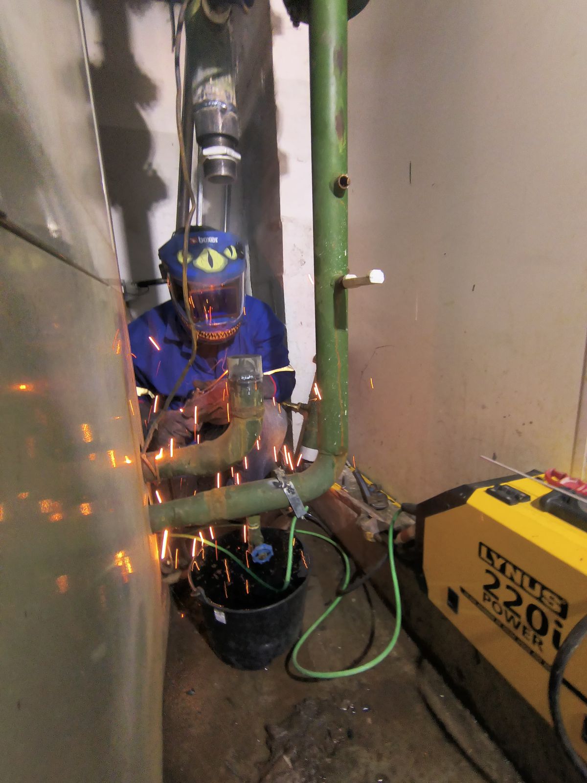 Técnico realizando solda em conexão hidráulica com maçarico